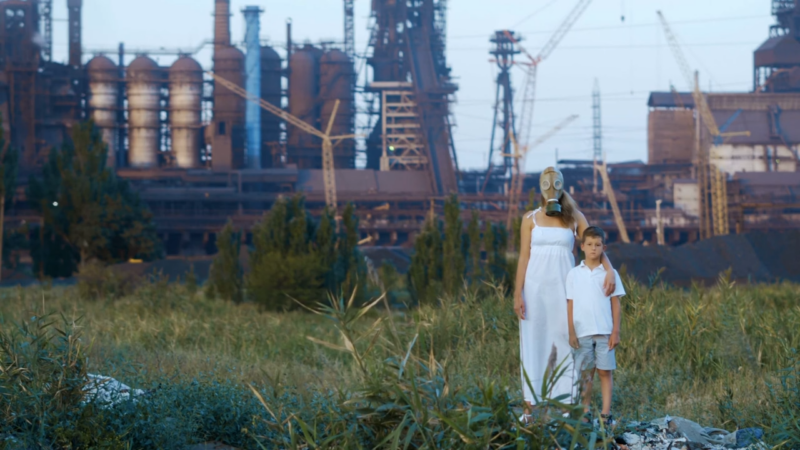 A mother and child in a heavily polluted environment near a factory, illustrating the impact of carbon dioxide emissions and air pollution on public health