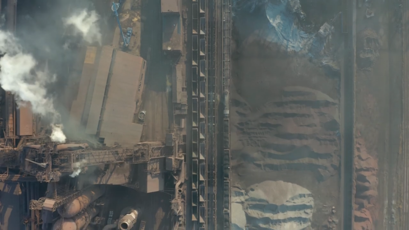 A top-down view of a factory releasing carbon dioxide and thermal pollution