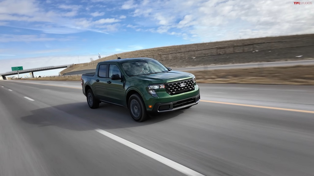 A green Ford Maverick Hybrid driving on an open highway, showcasing its fuel efficiency and appeal among dependable long-term vehicles
