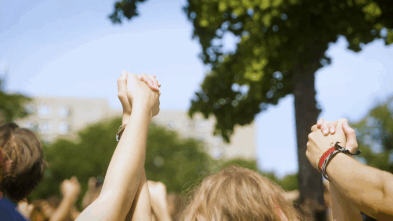 People hold hands in solidarity at an outdoor event, symbolizing unity and support for Horizon Europe’s climate mission