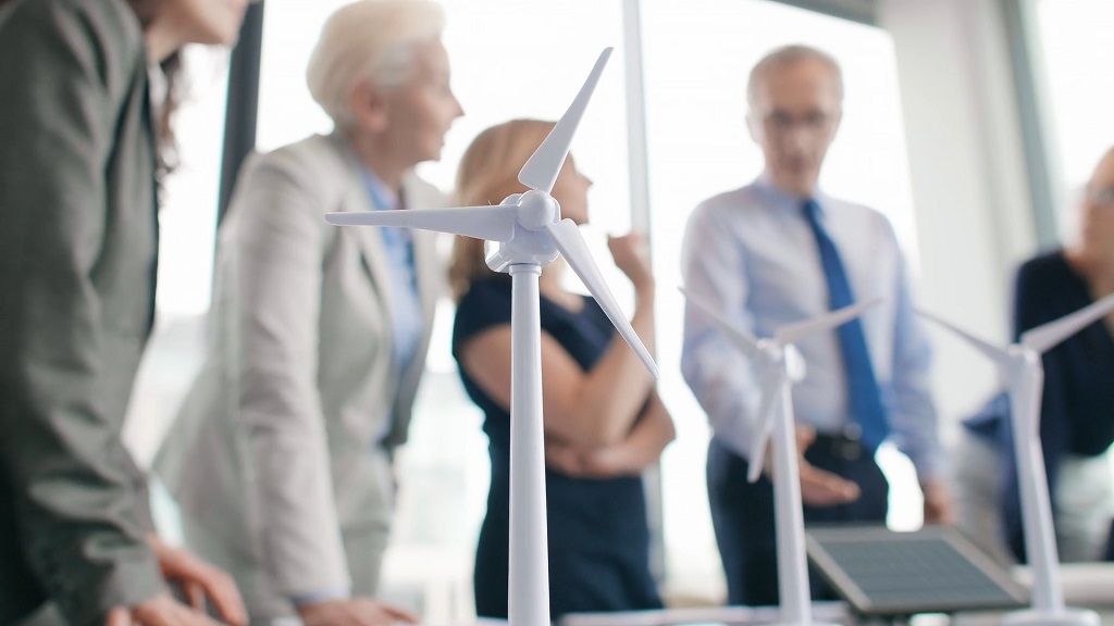 Business team discussing a project with wind turbine models on the table