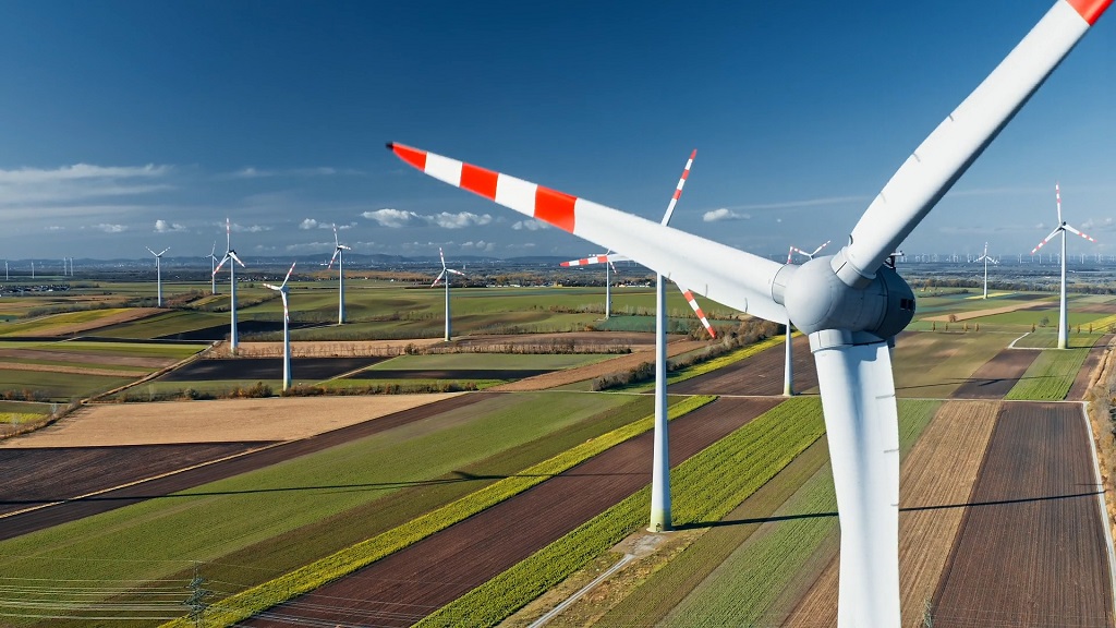 Large wind turbines on agricultural fields representing renewable energy solutions in rural areas