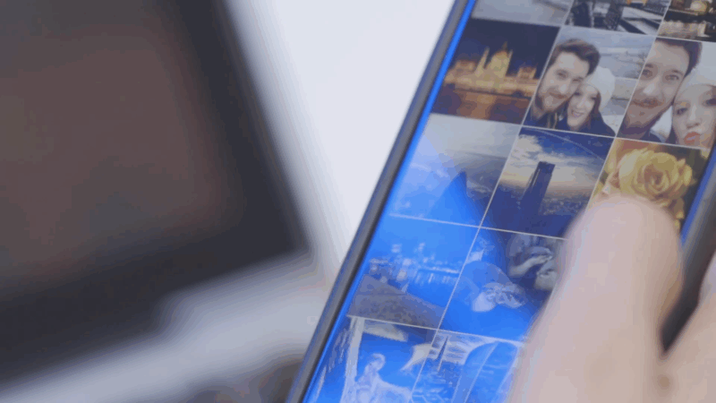 Close-up of a person using a Fairphone with photos on the screen, showing modular design in the circular economy