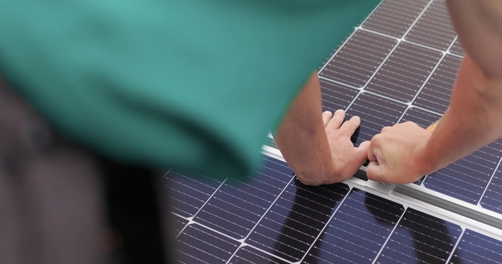Technicians securing solar panels during installation process