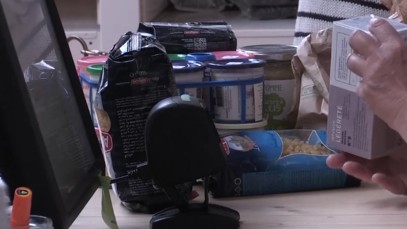 A person checks product labels on packaged food items, looking for misleading greenwashing claims