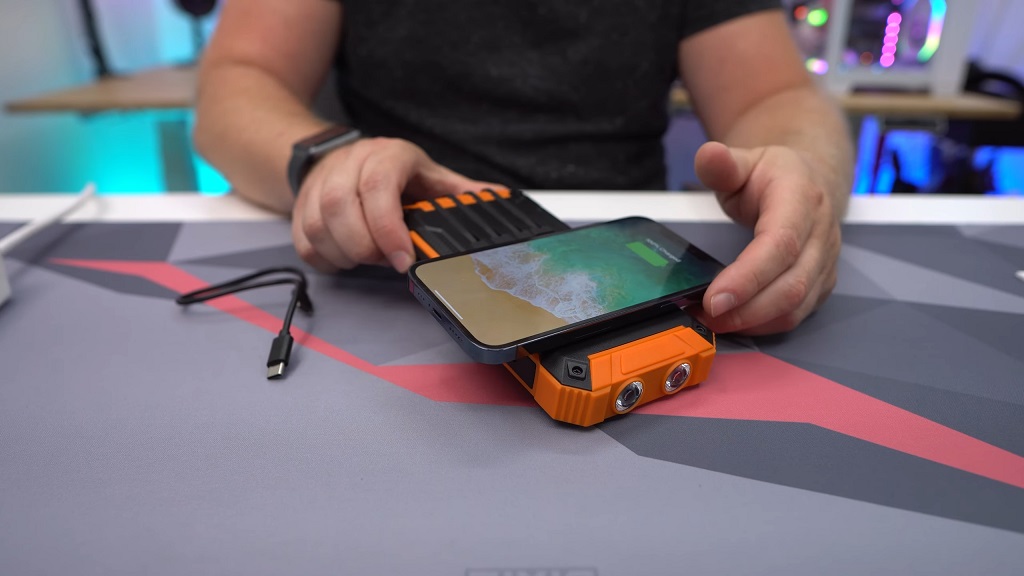 solar phone charger powering smartphone wirelessly on a rugged power bank