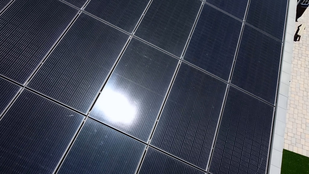 Close-up of dark solar panels on a rooftop in full sunlight