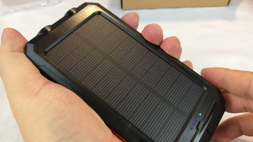 compact solar phone charger in hand with LED indicators