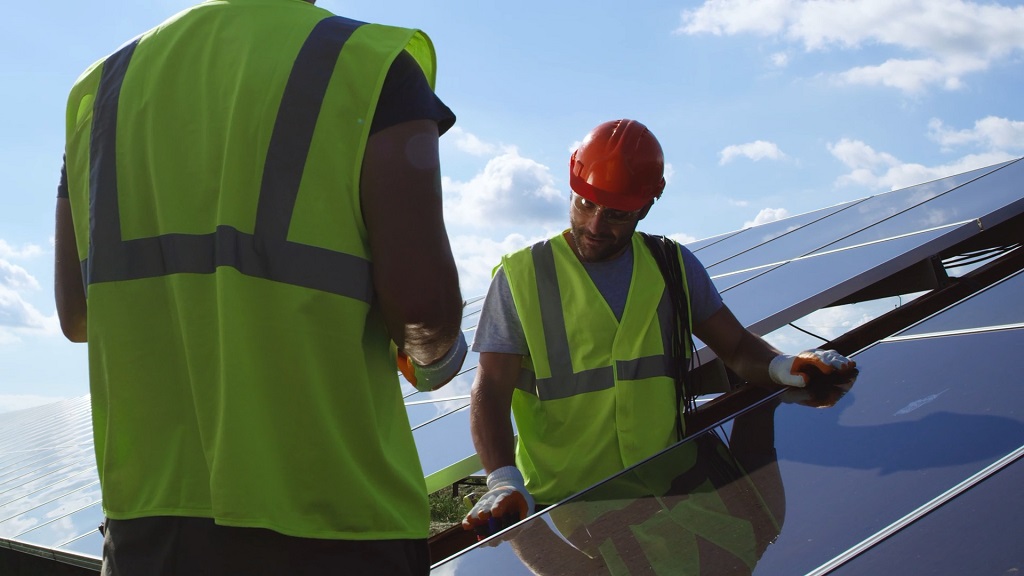 Two solar professionals discussing panel installation on site