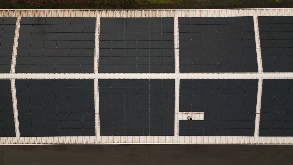 Aerial view of a large rooftop solar panel array used for renewable energy generation
