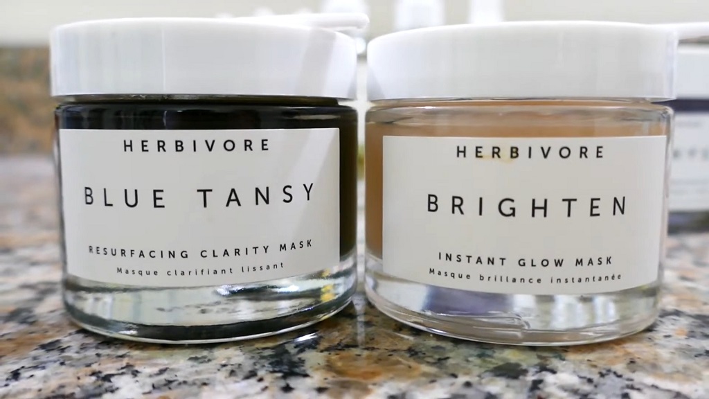 Herbivore Blue Tansy and Brighten face masks in glass jars with white lids