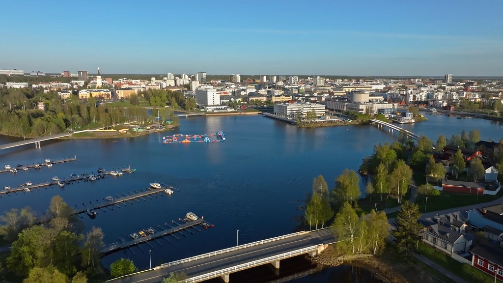 Aerial view of Oulu, Finland, showing the waterfront, marina, bridges, and modern cityscape