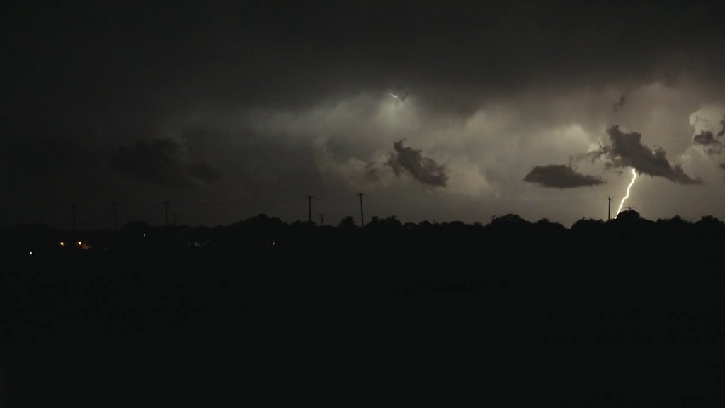 Lightning strikes in the distance during a storm, symbolizing environmental hazards that can impact solar panel systems