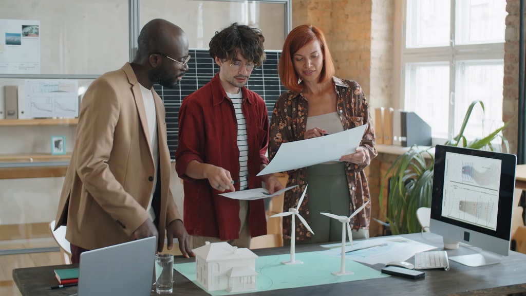 Close-up of professionals examining ESG performance reports and sustainability metrics on printed documents and digital dashboards