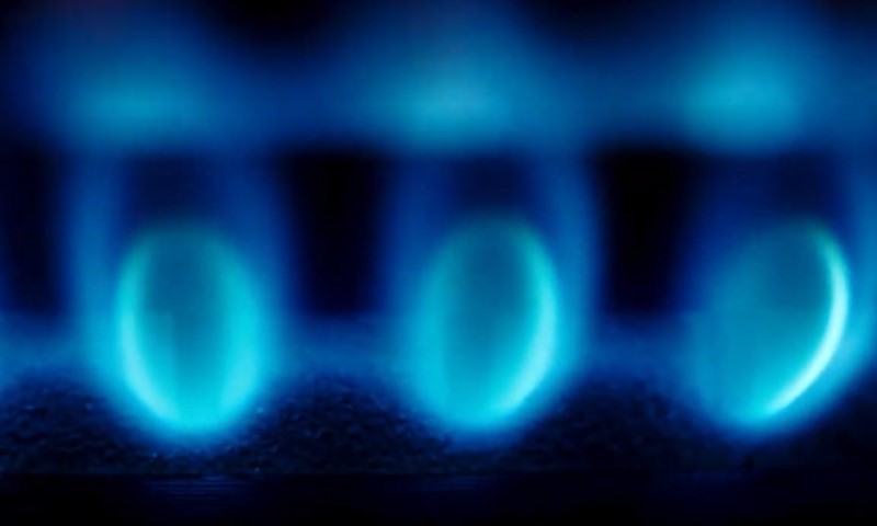 Close-up of vibrant blue flames flickering on a gas stove