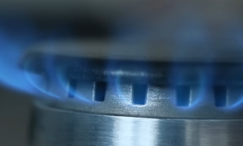 Close-up of a gas burner emitting vibrant blue flames