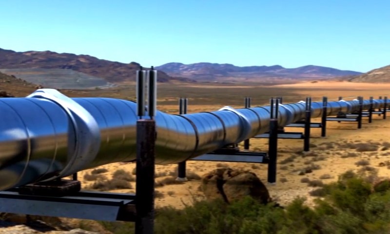 A large pipeline stretches across a desert landscape