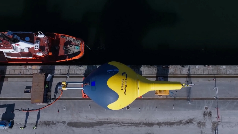 Wave energy converter device positioned at a harbor dock beside service vessels