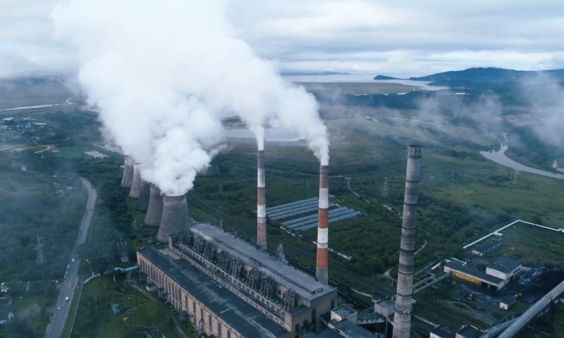 Aerial view of a power plant with towers emitting white smoke