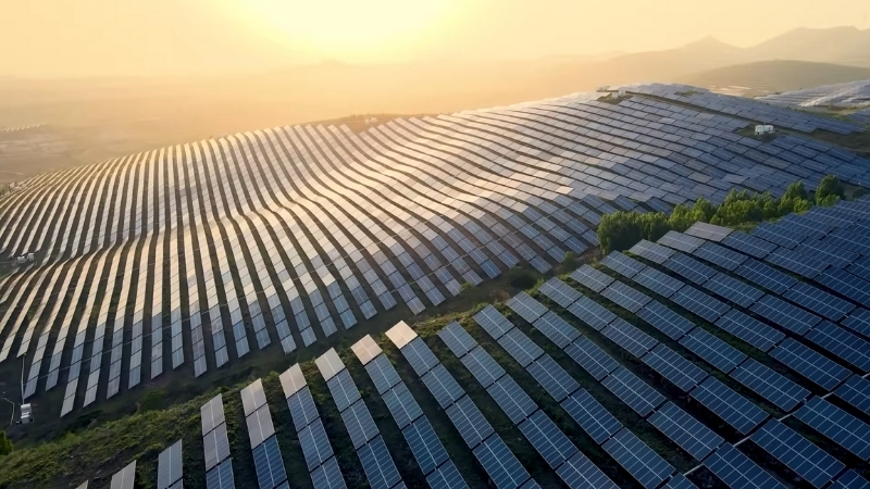 Large solar panel arrays across rolling terrain