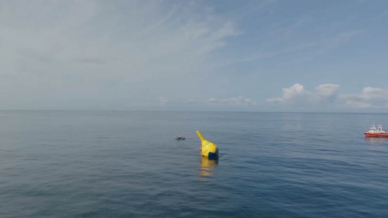 Yellow ocean buoy floating on calm sea surface under open sky