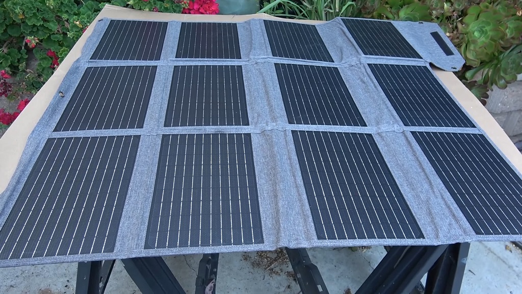 Foldable solar panel laid out outdoors, demonstrating portable solar charging for off-grid travel