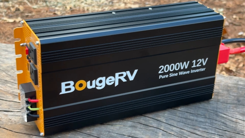 2000W 12V pure sine wave inverter connected to battery cables on a wooden surface