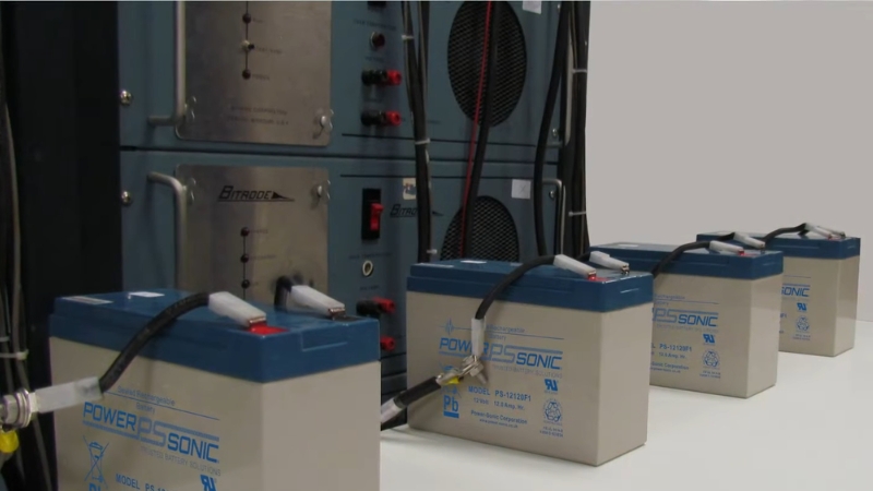 Industrial AGM and gel batteries connected to testing equipment during electrochemical performance analysis