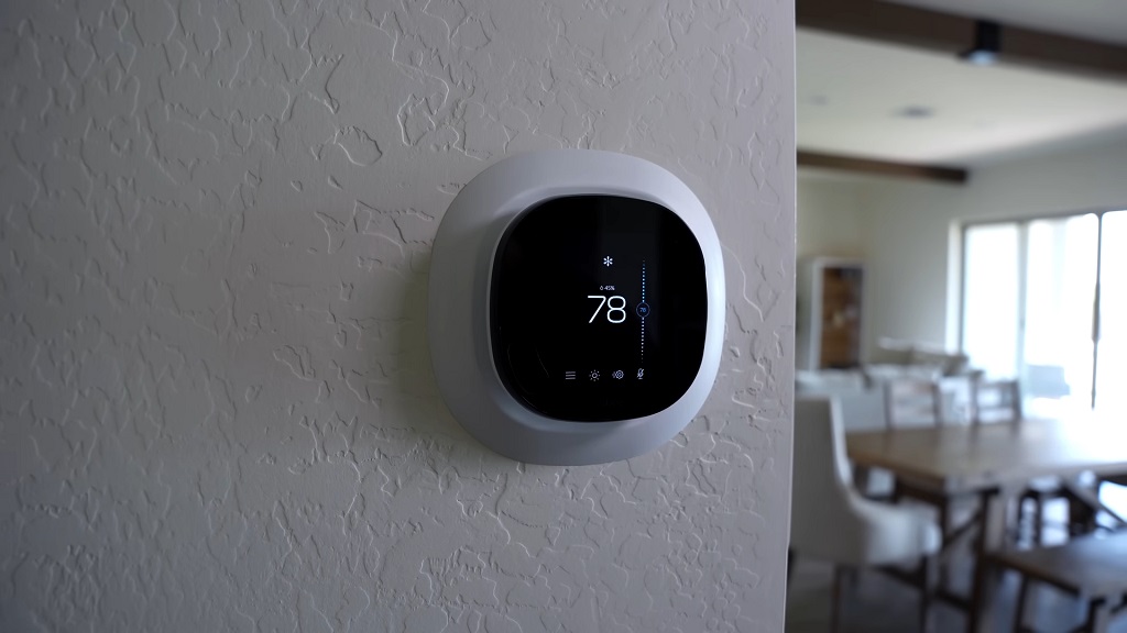 Wall-mounted smart thermostat controlling indoor temperature in a residential space