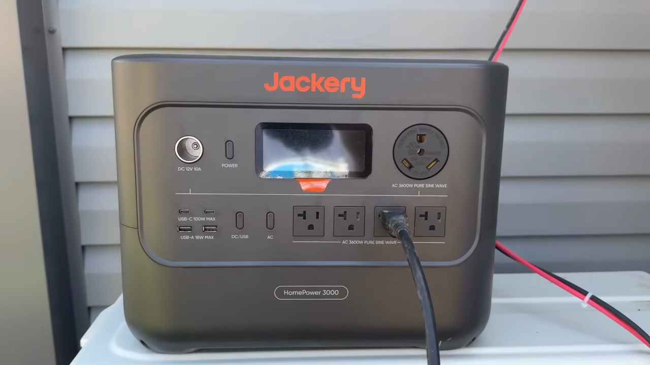 A Jackery portable power station with outlets and a display screen plugged in
