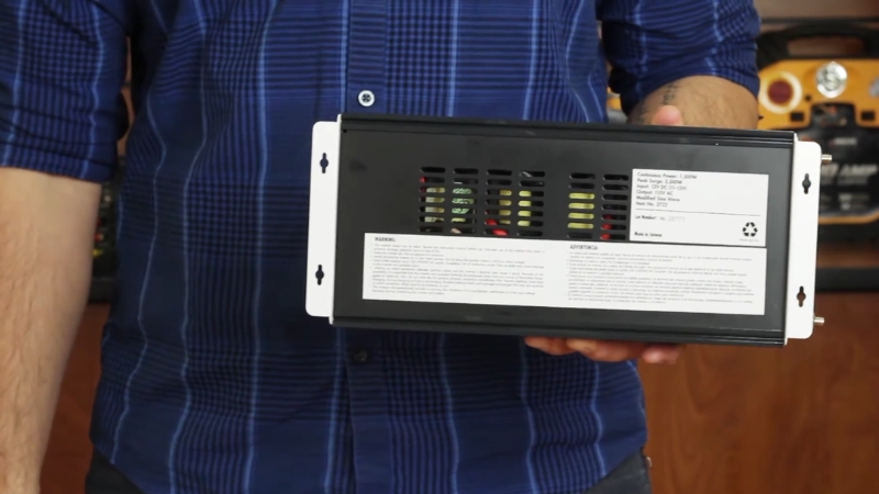 Person holding a pure sine wave inverter used to power sensitive electronic devices