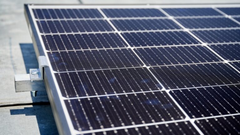 Close-up of a 400 watt solar panel mounted on a rooftop bracket in daylight