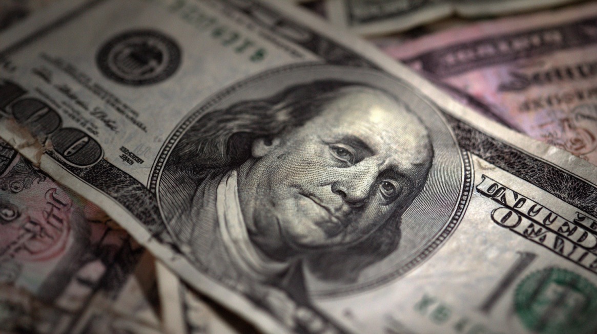 Close up of US dollar bills representing the cost comparison of renewable energy systems