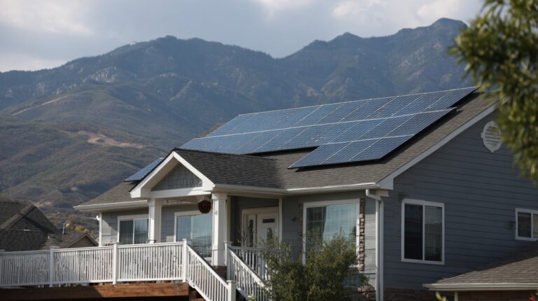 Suburban house with rooftop solar panels and mountains in the background