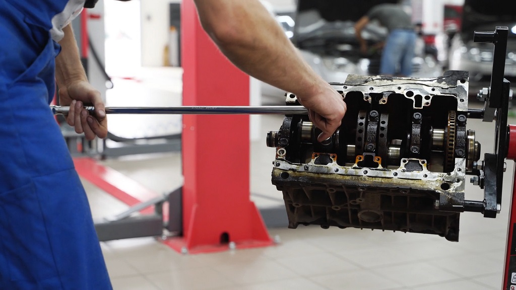 Technician inspecting an engine block in a workshop
