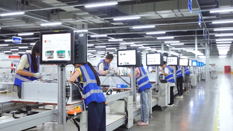 Workers assembling solar panels on a production line inside a factory