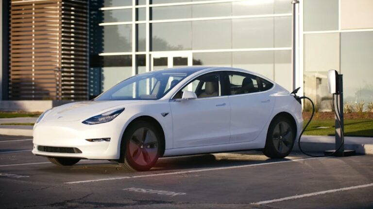 White Tesla charging at a station, highlighting Tesla battery module lifespan in real-world use