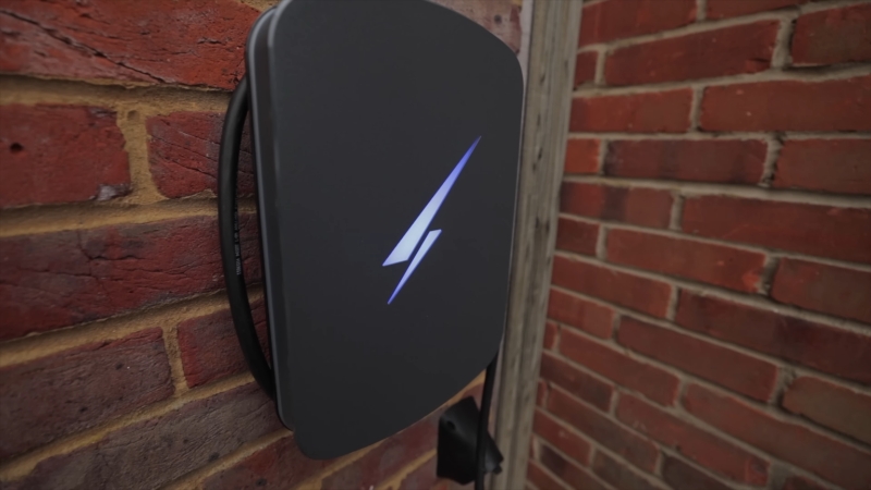 Wall-mounted EV charging station installed on an exterior brick wall