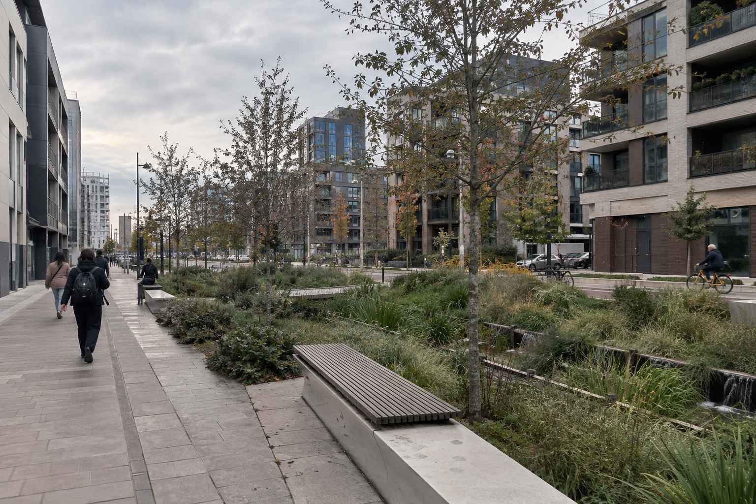 Modern European street with trees, planting areas, pedestrians and a cyclist.