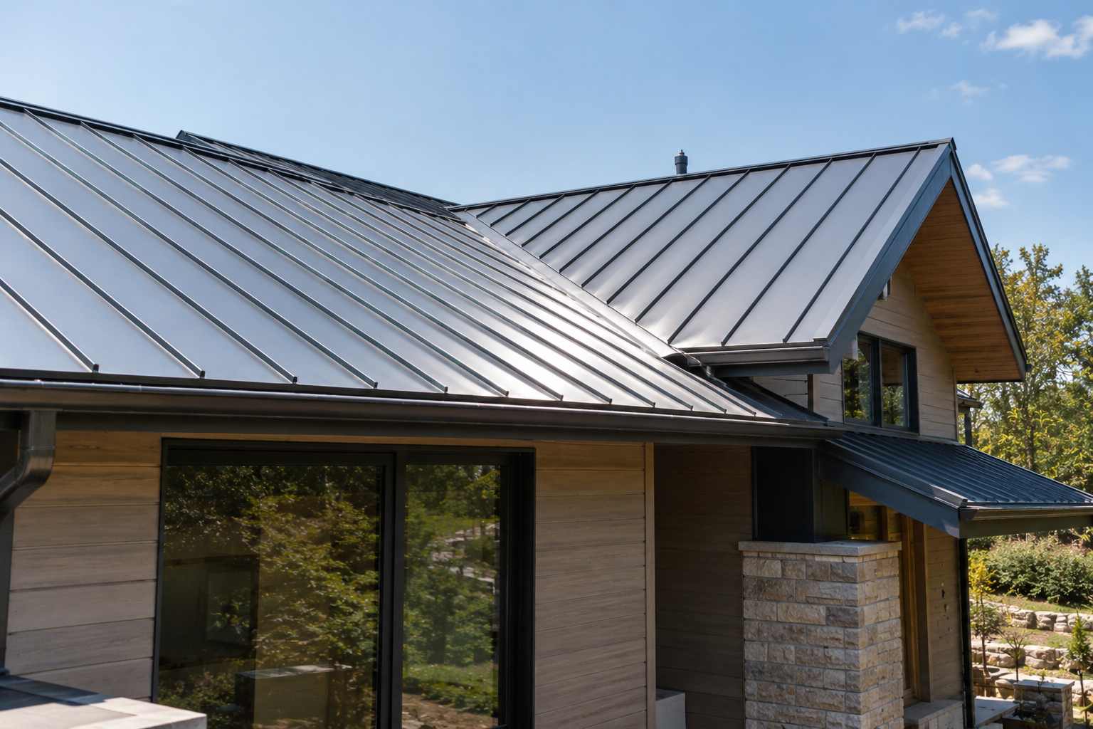 Modern home with reflective standing seam metal roofing and light-colored exterior siding.