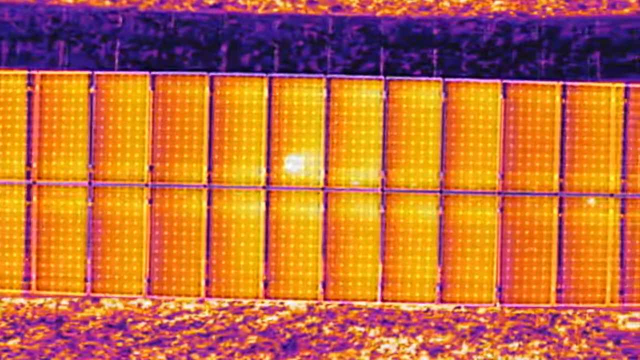 Thermal image of solar panels showing a bright hot spot on one module.