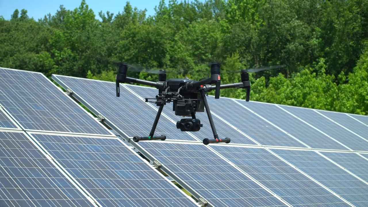 Inspection drone flying above rows of solar panels during a maintenance check.